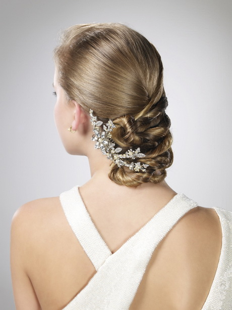 Novia de espaldas en la que se ve el peinado recogido con una pinza de piedras.